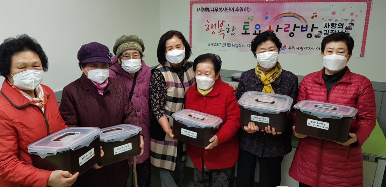 예빛나무 봉사자가 어르신에게 김치를 전달하는 장면